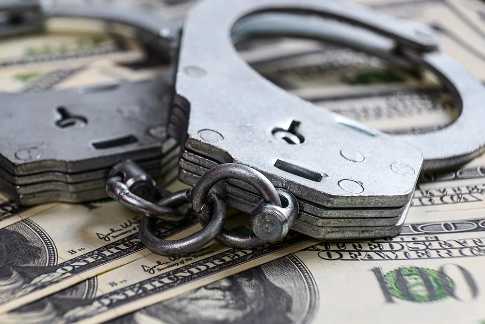 Cash in US Dollars, Real Handcuffs. The Concept of Arrest, Corruption, Bail, Crime, Bribery or Fraud