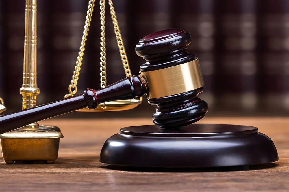 Wooden Gavel With Golden Scale On Table