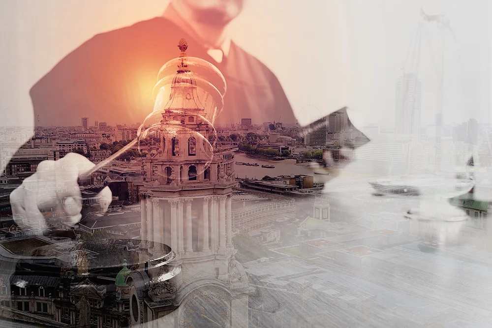 Double exposure of justice and law concept.Male judge in a courtroom with the gavel and working with holy book and brass scale on wood table with London city