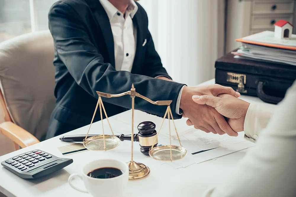 Businessman shaking hands to seal a deal with his partner lawyers or attorneys discussing a contract agreement